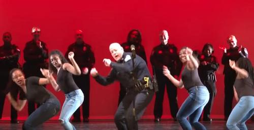 Polizeibeamte tanzen mit Schülern der High School in einer epischen Bühnenshow
