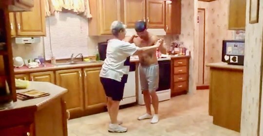 Sohn nimmt Mutter bei der Hand und erfreut das Internet, während sie zusammen tanzen