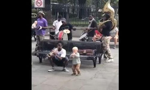 Süßes Kleinkind tanzt mit Straßenkünstlern in New Orleans